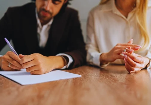 Married couple signing decree papers getting divorced in lawyers office. safeguard a business in a divorce