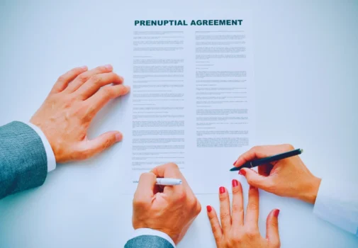 Young man an woman signing a prenuptial agreement. Prenups and Postnups for High-Net-Worth