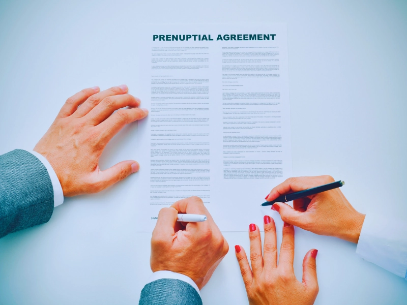 Young man an woman signing a prenuptial agreement. Prenups and Postnups for High-Net-Worth