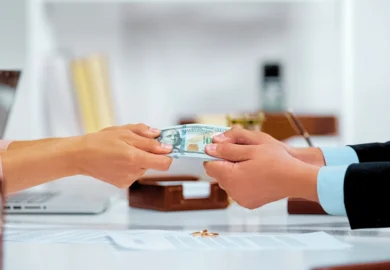 Two people handing over a stack of US dollar bills. protect your financial future